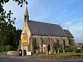 Stone building with arched windows and small turret.