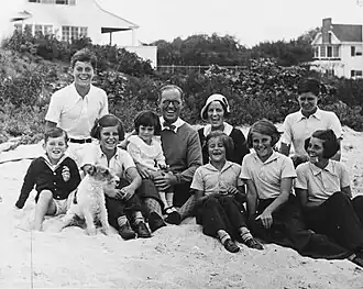 Family portrait taken outside with children surrounding their parents