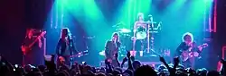 a color photograph of members of the group the Strokes performing on stage