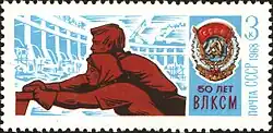 A postage stamp shows a man and woman pushing a heavy object, with the image of a large dam in the background.