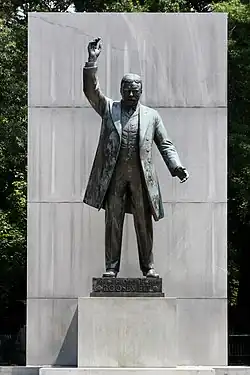 Statue of Roosevelt holding an arm up during an oration