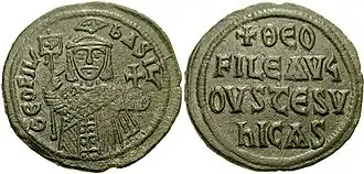 Image of bronze coin, a standing crowned man holding a labarum and a globus cruciger on the obverse, with a Greek-Latin inscription on the reverse