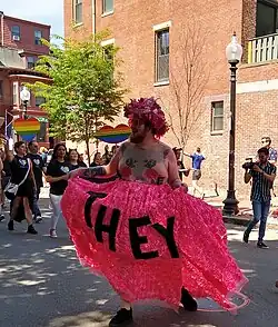 Person with large "they" banner in the streets of Boston, Massachusetts, USA