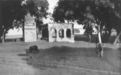 A black-and-white photograph of an Indian roadside structure