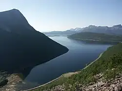 A calm body of water snakes away between steep slopes.