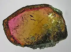 A stone cut open and polished, revealing a bright rainbow of colors