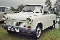 Two-door sedan with a man standing behind it