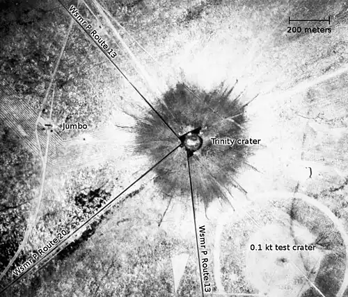 An aerial photograph of the Trinity crater shortly after the test[h]