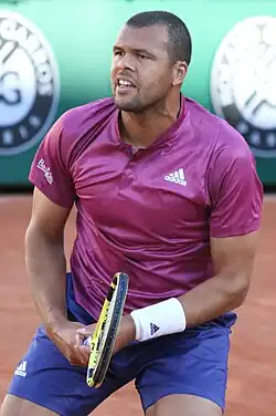 Tsonga in a red shirt looking into the camera.