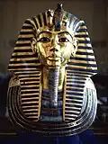Tutankhamun's mask - King Tutankhamun, son of Akhenaten, returned to the former capitol and restored the cult of Amun to its former influence; although he died young and was not considered significant in his own time, the 1922 discovery of his KV62 intact tomb by Howard Carter, made him relevant as a symbol of ancient Egypt to the modern world