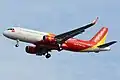 An aircraft of VietJet Air with the national flag painted below the windshield. The yellow-star-on-the-red-background symbolism of the Vietnamese flag is also used to decorate the engine.