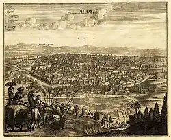 Print depicting Isfahan in background, with a caravan of men and camels on road in foreground