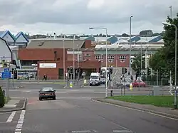 Red brick factory buildings seen across roads and traffic light controlled junction