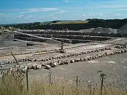 Large expanse of exposed grey rock. Fence in the foreground.