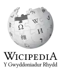 Wikipedia logo displaying the name "Wikipedia" and its slogan: "The Free Encyclopedia" below it, in Welsh