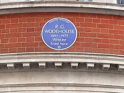 round blue plaque marking Wodehouse's residence, reading: P. G. Wodehouse, 1881–1975: Writer, lived here