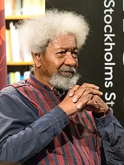 An aged black man, with white hairs and medium-sized moustache