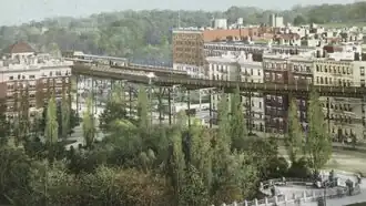 Postcard depicting a forest in Morningside Park with an IRT station and high-rise buildings in the background