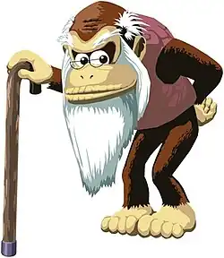 A thin, elderly gorilla scowling and standing with a cane. He has a long white beard, small glasses, and a taupe sweater vest.