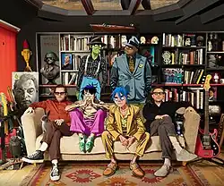 Gorillaz in 2020. Jamie Hewlett (far left) and Damon Albarn (far right) with animated members Murdoc Niccals (top left), Russel Hobbs (top right), 2-D (bottom right), and Noodle (bottom left).