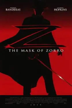 A dimly-lit figure sporting a rapier, a black costume with a flowing Spanish cape, a flat-brimmed black gaucho hat, and a black cowl sackcloth mask that covers the top of the head from eye level stands with the film's title: THE MASK OF ZORRO in white font. He is silhouetted against a red hue fading to black at the top with the star billing of ANTONIO BANDERAS and ANTHONY HOPKINS.