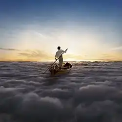 A man in a white shirt and tan pants stands in a Thames skiff at the center of the image. He stand-up paddles the Thames skiff across a sea of clouds, heading towards the sun.