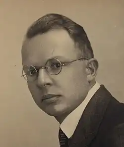Photo of a man with short hair wearing glasses